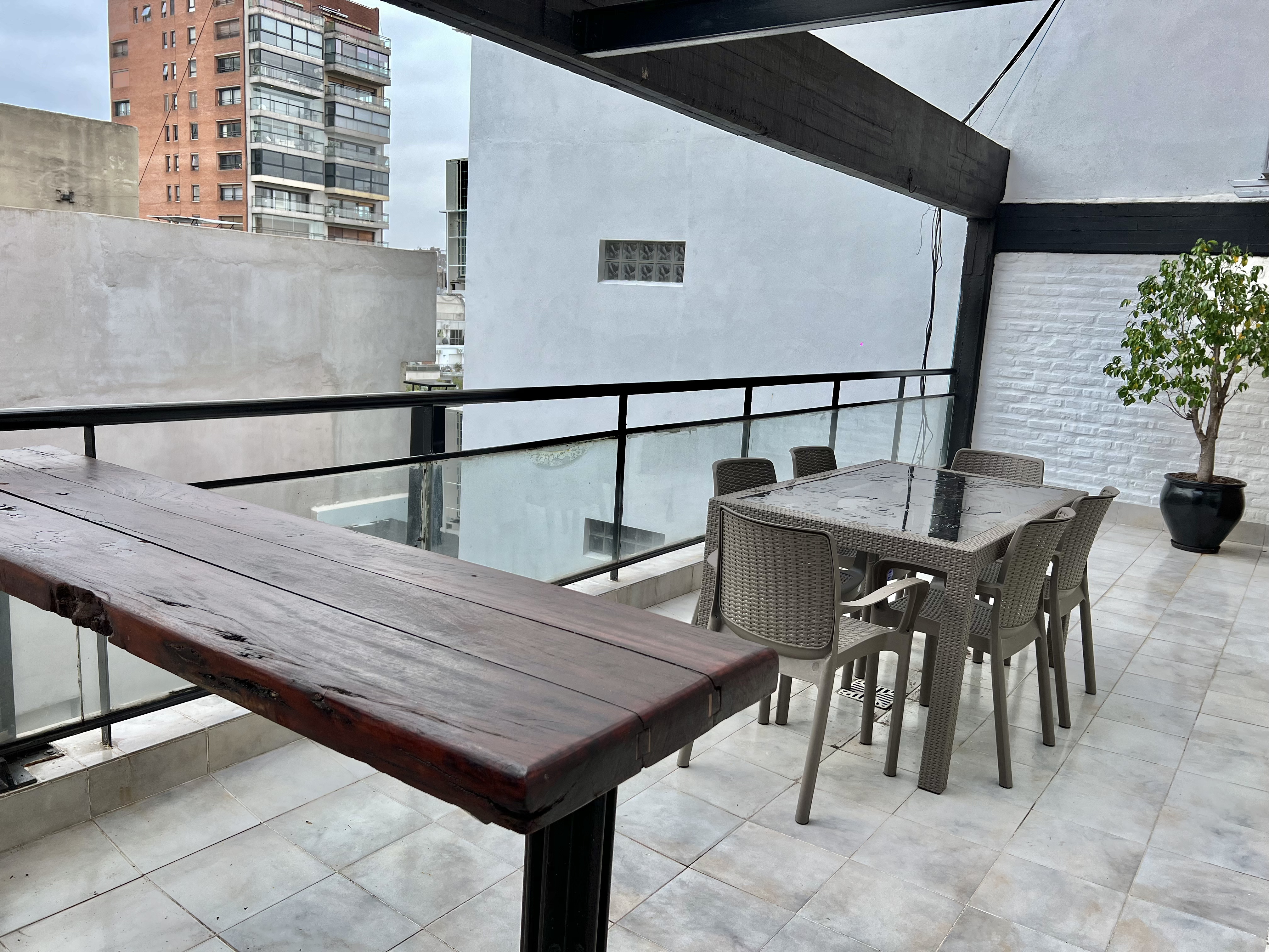Terraza privada con mesa y barra de madera